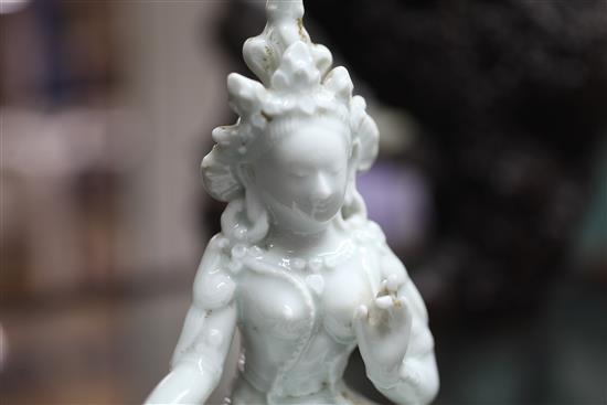 A Chinese white glazed porcelain figure of Green Tara, seated in a rootwood arbour, 19th century, total height 27cm